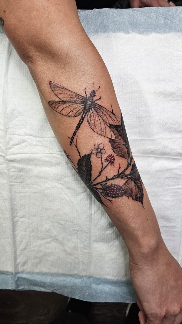 Dragonfly with berries, fine-line tattoo on a forearm